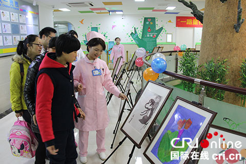 　　大家正在参观“特殊儿童”们亲手创作的作品。（摄影 邱美智）　　