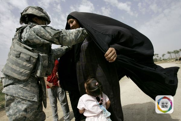 2008年5月8日,一名美军女兵在伊拉克对当地妇女搜身。(图片来源:新华/法新)