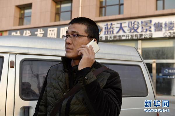 在宁夏银川市“蓝天骏景”售楼中心外，何胜在给开发商负责人打电话要债（12月6日摄）。新华社记者 彭昭之 摄
