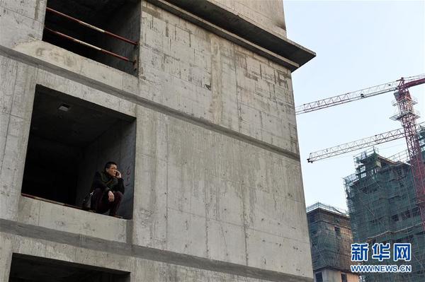 何胜在已经停工一年的工地上给承建商打电话要债（12月6日摄）。