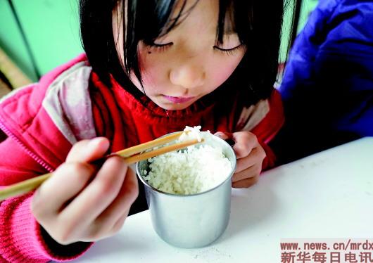 　▲在江西省修水县大椿乡柏树村小学,学生杨欣在吃自带的午饭。由于家庭条件差,她的午饭除了米饭什么也没有(2014年11月28日摄)。　　　　　　　　　　　　　　新华社记者陈子夏摄