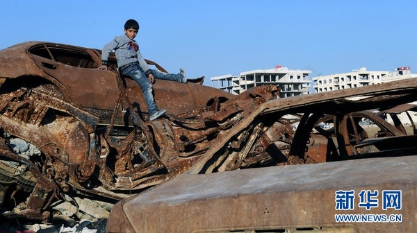 2015年12月7日，在叙利亚首都大马士革贾拉曼纳镇，一名男孩爬上一辆废旧汽车。