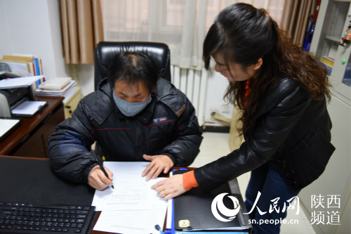 的哥廖师傅正在办理相关手续 手续完成后他将领到一万元的爱心补助金。梁锦 摄