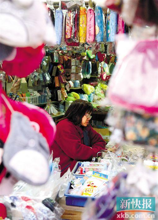 ■生意冷清,摊主在玩手机打发时间。