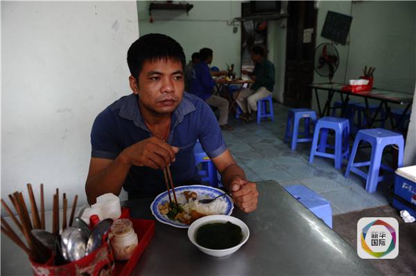 　　在黎文明妻子的饭店吃饭的外来务工人员。（图片来源：新华/法新）