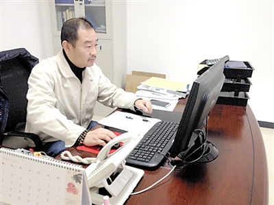 汪军正在办公室办公。