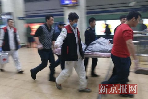 男子已死亡，后装入银色袋子由担架抬走。新京报记者鲁千国摄