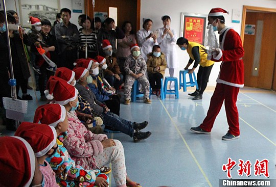图为志愿者扮演的圣诞老人给孩子们讲故事。刘林子 摄