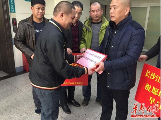 长沙江永商会筹委会会长邓士超将近日筹集的34567元善款交到欧阳永辉父亲的手中。