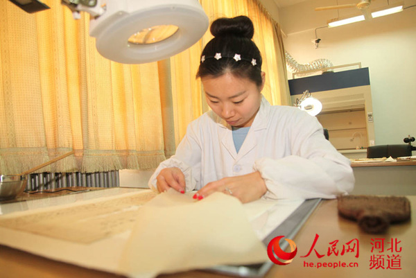 图为邯郸学院李楠老师正在使用灯光补书板修复文书。 马君 摄