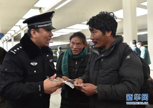 张雨在拉萨火车站解答两名藏族群众的询问（1月12日摄）。 新华社记者 罗晓光 摄