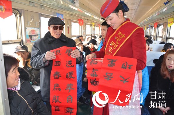 1月26日上午,在陇西开往天水的城乡文化列车上,列车员为旅客送春联 郭颂霞 摄