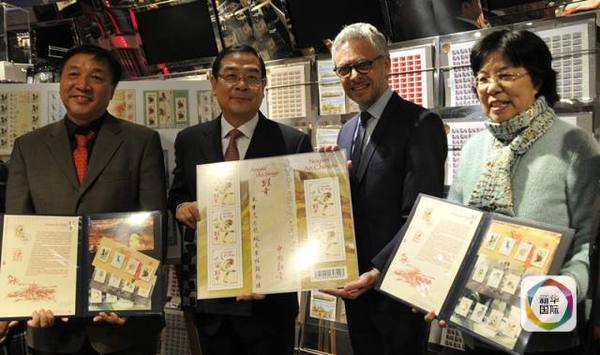 　　设计师李中耀（左一）和其他嘉宾共同展示猴年邮票和十二生肖纪念封。