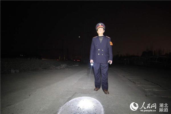 0：52分，车站助理值班员蒋利刚徒步前往停留列车地点做好安全防护措施。（刘军民  摄）