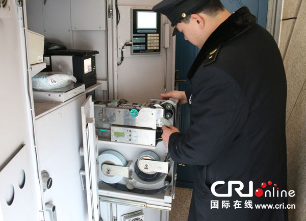 石家庄火车站自动售票组刘赫为自动售票机更换磁介质票卷。摄影:杜军帅