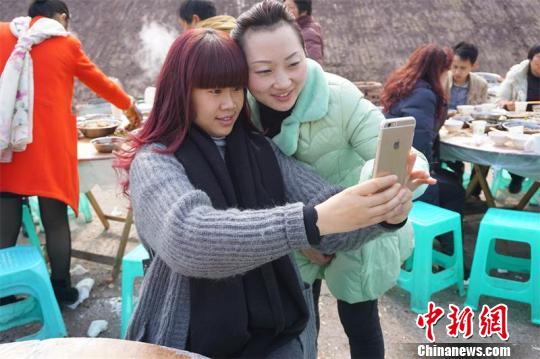 儿时的伙伴梁超（左）雷丽红（右）在团年饭前一起自拍留影。　郭飞　摄