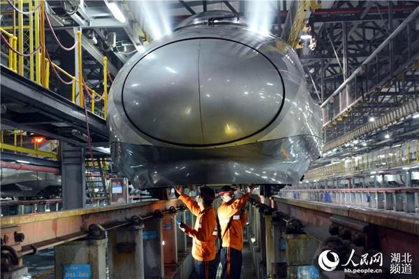 零点,武汉铁路局武汉电务段职工正在对动车组底部进行检查、整修。