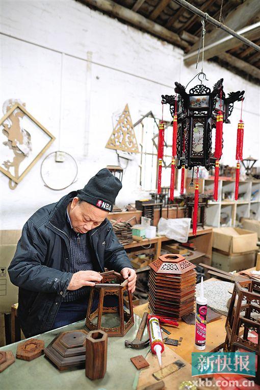 ■罗昭亮师傅在作坊内组装小型红木宫灯。