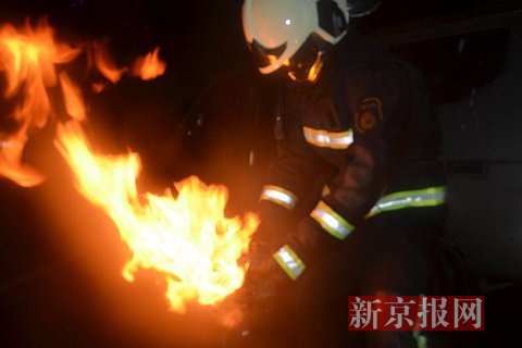 两名消防官兵将煤气罐抱出后扑灭。通讯员 王凯 摄