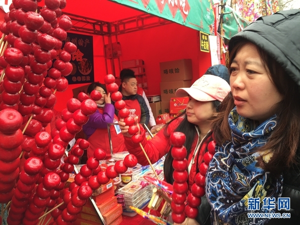 图为2月11日,游客正兴意盎然地逛着北京厂甸庙会,采购喜爱的商品。