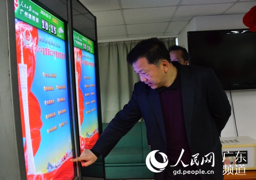 慎海雄体验人民日报社电子阅报栏。林龙勇 摄