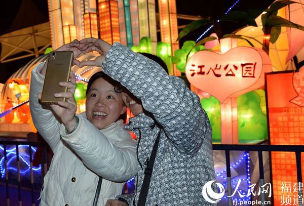 一对情侣在江心公园灯组前做同心状自拍留念。江心公园在福州也被称为情人岛。李挺摄