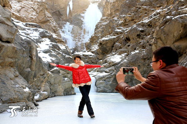 游客在博湖县库鲁克塔格山冰挂奇景拍照留念。