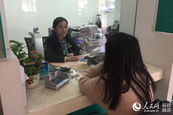 大年初三，青争还在银行柜台前为客户办理业务 邹家骅摄