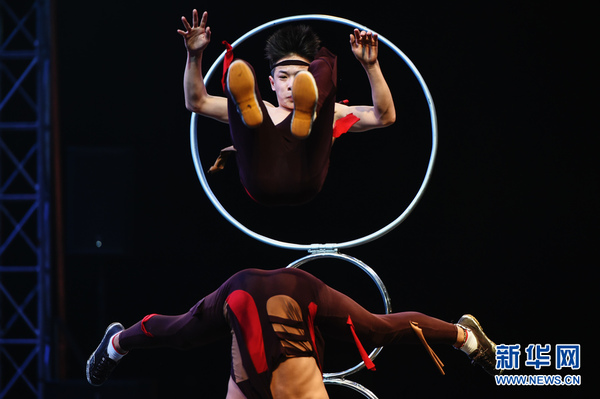 2月20日，来自中国山东省杂技团的演员在泰国曼谷表演钻圈。新华网记者李芒茫摄