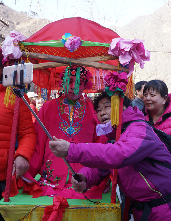 京西古幡盛会现场，游客与演员自拍合影。（摄影：中国日报记者刘慧）