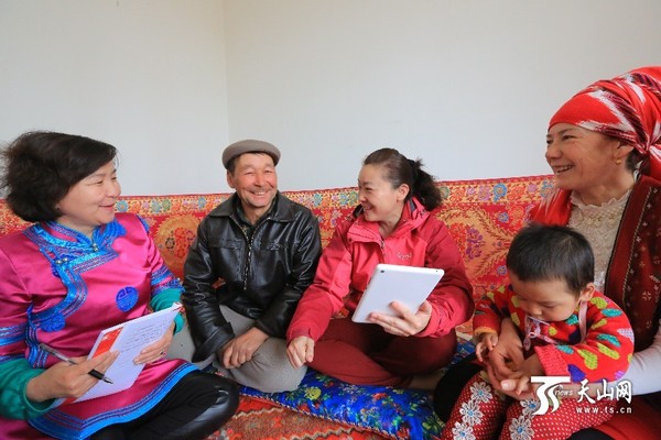 工作组干部向艾海提·马木提一家讲解惠民政策。