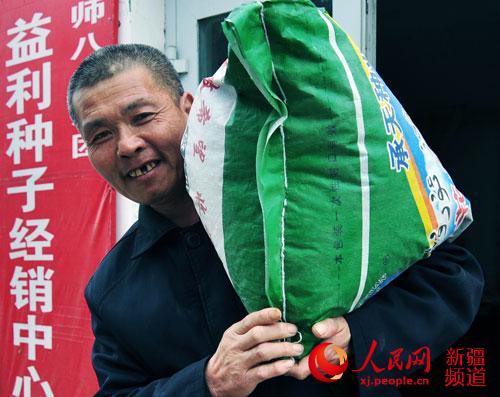 二连棉花种植户朱明志将选购的棉种搬回家。