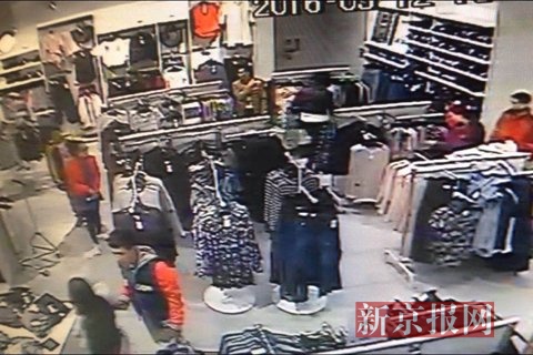 监控录像，两嫌疑人正在服务店内观察。