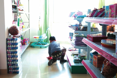 晋江市育婴院，一个孩子在爱心室里挑选玩具。很多爱心人士为这里的孩子们捐助了学习和娱乐用品，孩子们可以在老师的安排下选择自己喜欢的用具。