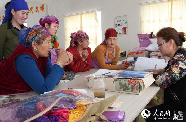 绣娘做刺绣产品。