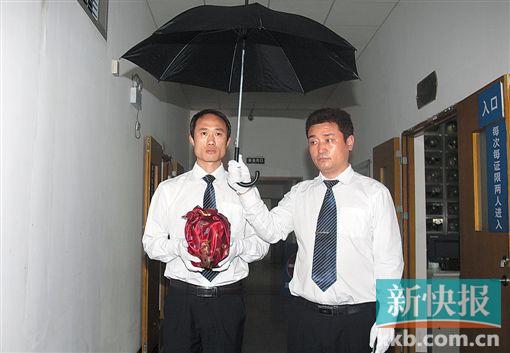 ■第二步:工作人员撑伞将骨灰抱出。