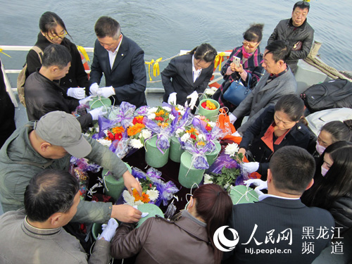 家属在工作人员的指导下，将亲人的骨灰装入由海泥和陶土制成的降解罐中。