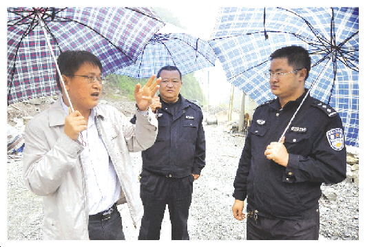 　　2015年威信县遭遇大洪水,王永明(左)在受灾现场指挥道路抢险救灾。　　　　　　　　　　　　　(资料图片)