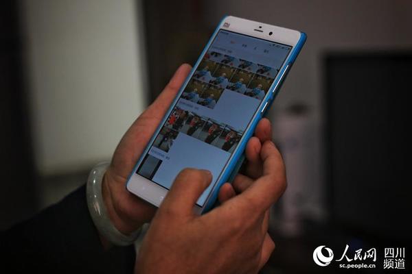 想念父母和孙子的时候，武静就看看手机里的照片。（朱虹 摄）