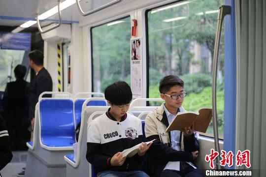 市民在有轨电车上阅读书籍。　泱波　摄