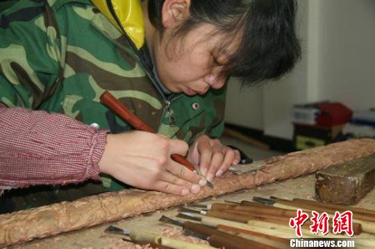 雕刻艺人正为香港客户订制的桃木剑赶工。　张继航　摄