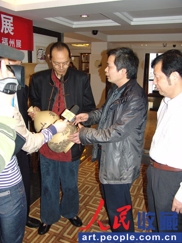 狄夕明（右二）在向嘉宾和媒体介绍紫砂作品