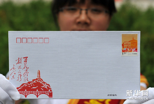 5月23日，工作人员展示《发表七十周年》纪念邮票首日封。新华网图片 祁小军 摄