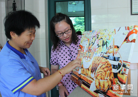 8月29日，油画作者徐珺（右）在展示画作。新华网图片 许晟 摄
