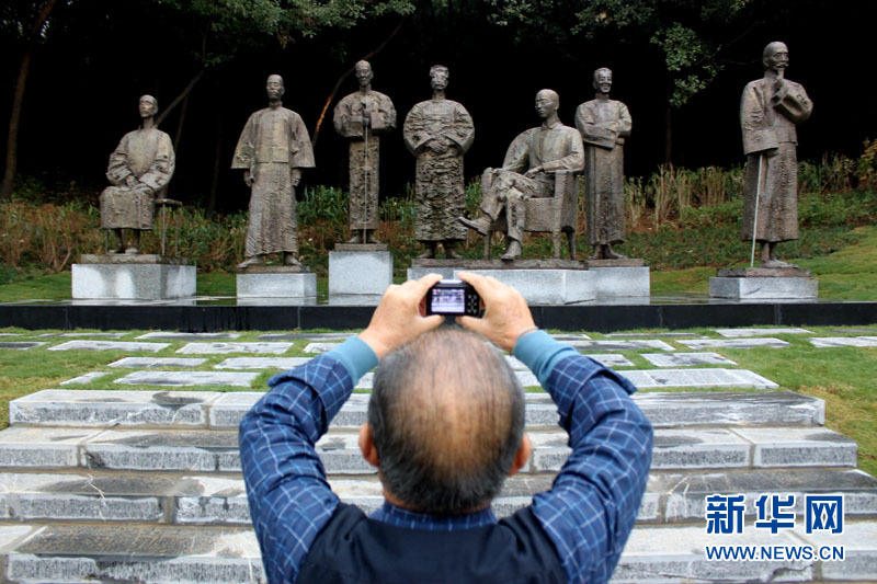 在芜湖雕塑公园内，一位市民在拍摄雕塑展品《文化生态·文人中国》。