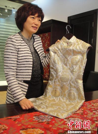 南京云锦研究所副所长张玉英向参观者讲述旗袍的用料和款式。　孙莹　摄