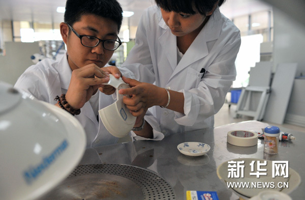 修复实验室的工作人员在修复瓷器（5月28日摄）。新华网图片 施鳗珂 摄