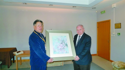 李勇锋（左）向波兰格但斯克市教堂主教代表Jerzy Ziolko赠送了王荣先生的油画。