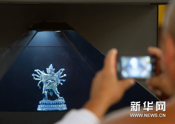 8月20日，一名游客拍摄将在“圆明重光——圆明园旅游文化莫斯科展”中展出、用触控屏数字全息柜展示的展品：“铜鎏金金刚”。新华网图片 罗晓光 摄
