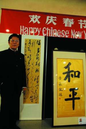 　　张旭光与潘基文秘书长题写的“和平”书法作品合影。